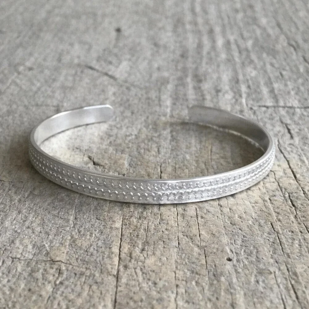 Brushed sterling silver scalloped open cuff bangle bracelet with satin finish.